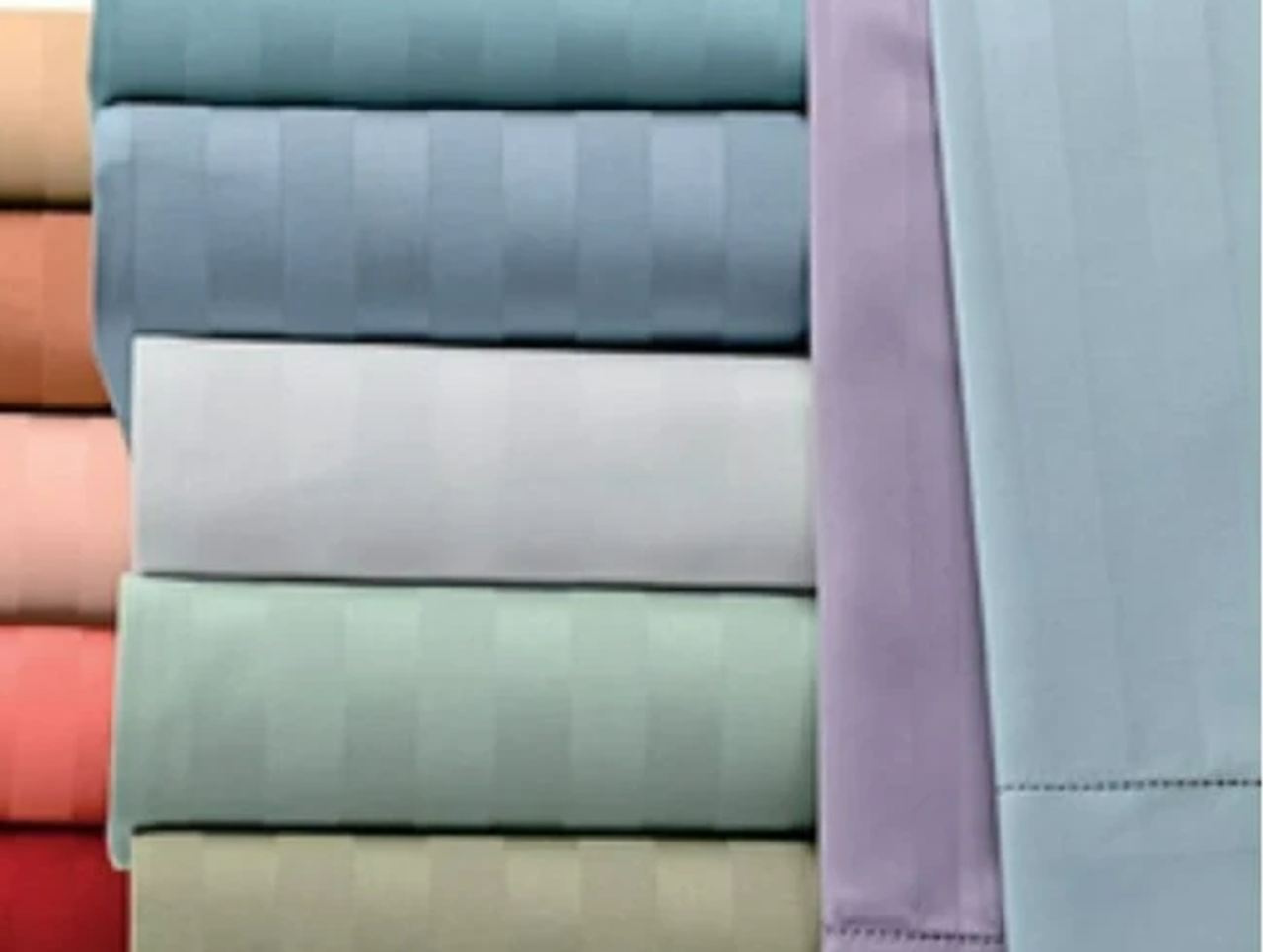 Folded stacks of striped cotton bed linen.