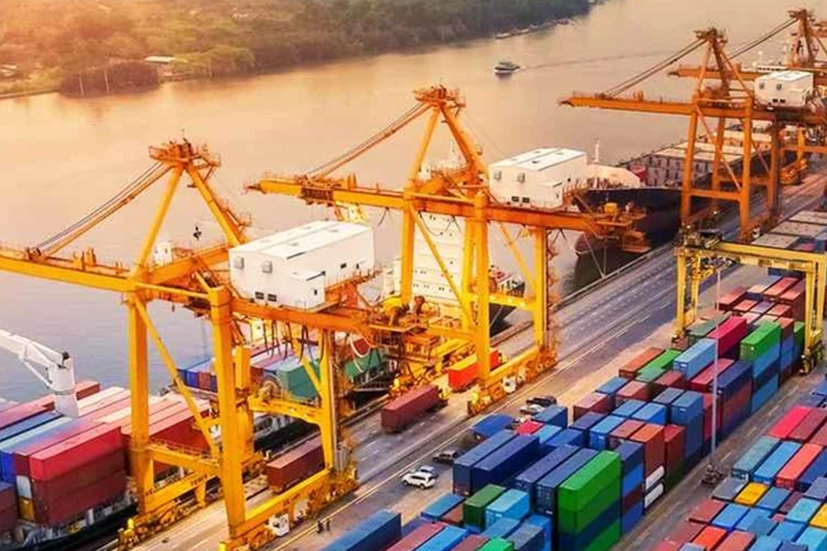 Gantry cranes loading containers onto a vessel at a port terminal.